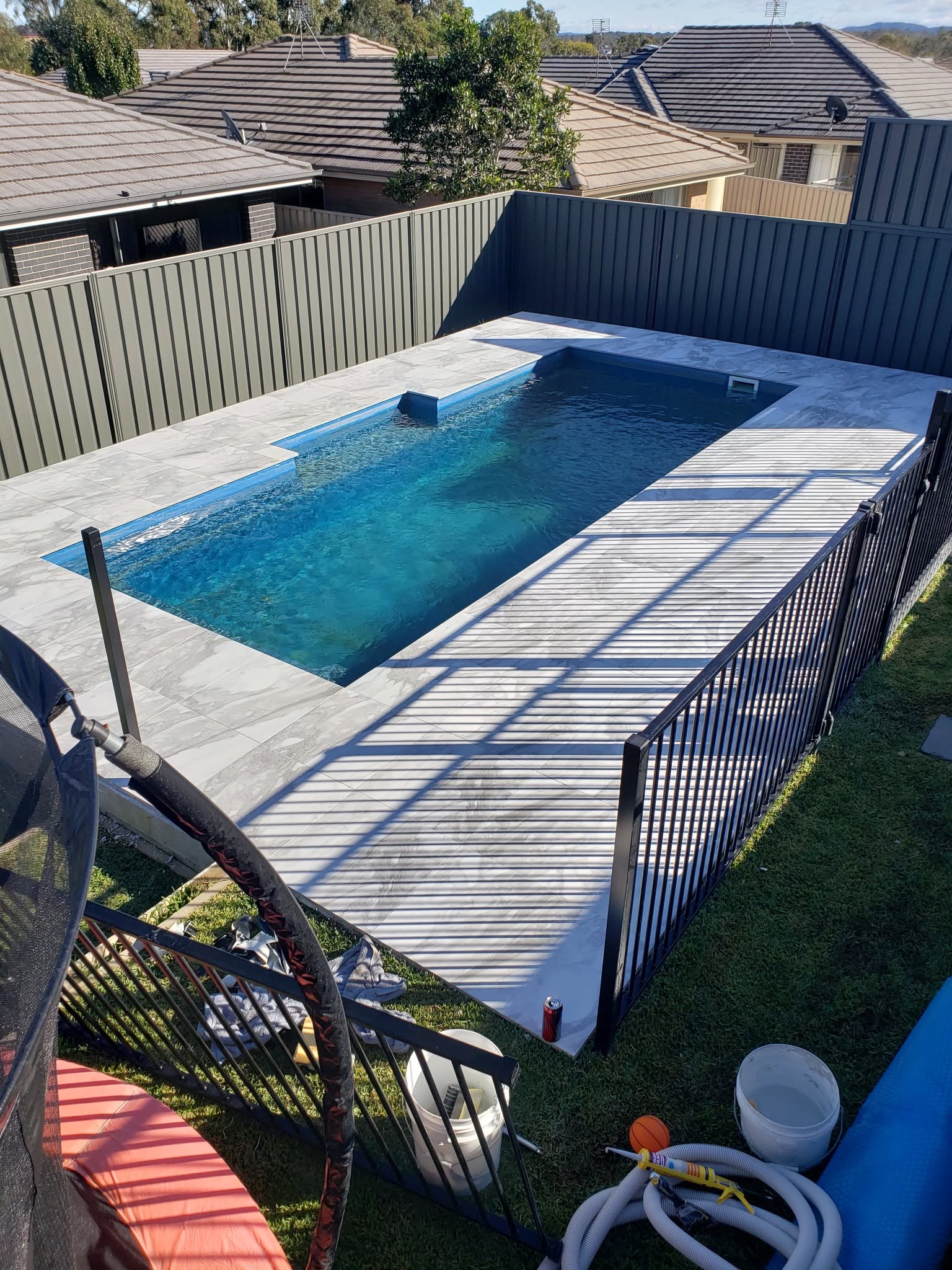 Finished Fibonacci pool build with paving and pool safety fencing