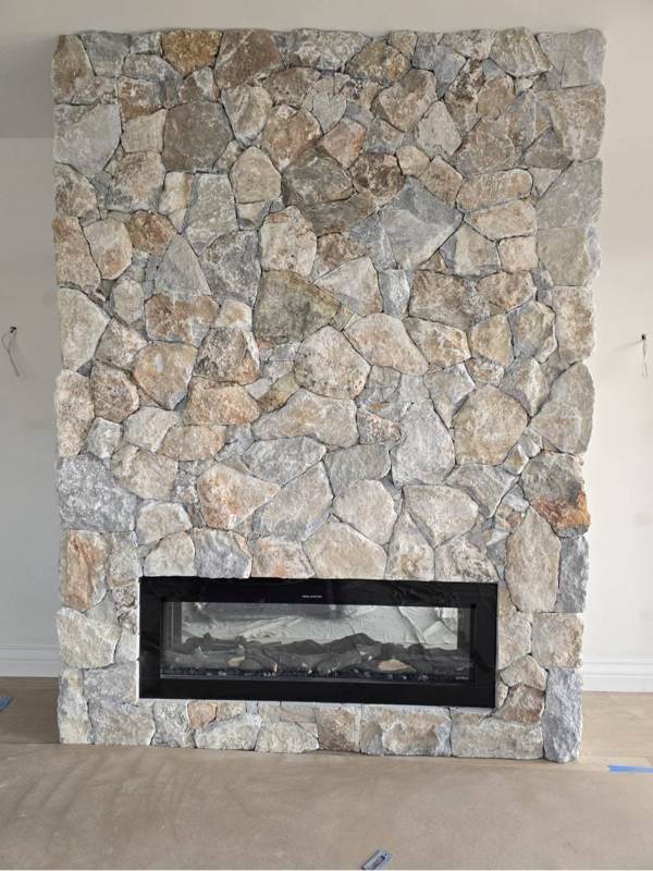 Natural stone cladding feature wall around an indoor fireplace